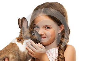 Little girl kissing cute brown bunny