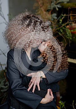 Little girl kissing her mom. Stylish hairstyles