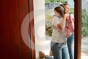 Little girl kissing her mother. Young mother hugging her daughter. Loving mother hugging daughter before school outside