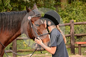 Little girl kissing her pony