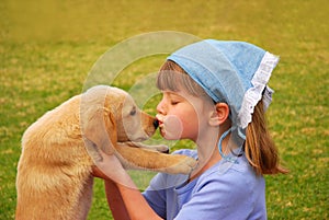 Little girl kissing her puppy