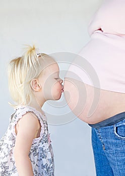 Little Girl Kissing Mom's Belly