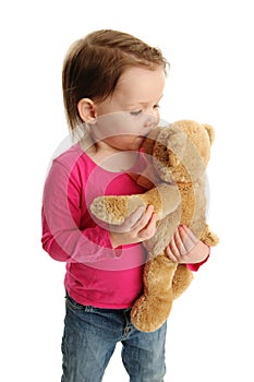 Little girl kissing teddy bear