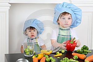 Little girl in kitchen apron and cap with large photo