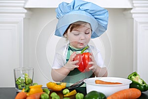 Little girl in kitchen apron and cap with large photo