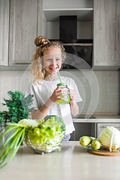 Little girl the kitchen. Green fresh vegetables and salad, healthy food