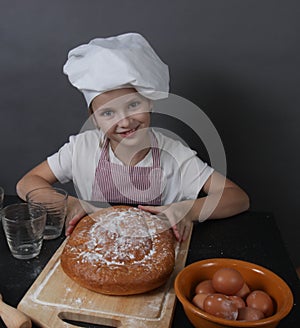 Little girl kneads dough