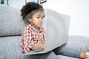 Little girl with laptop .afircan kid using laptop.