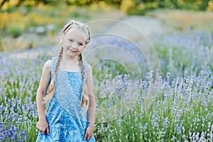Little girl in lavender field. kids fantasy. Smiling girl sniffing flowers in summer purple lavender field