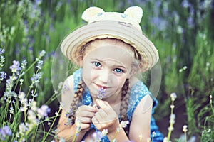 Little girl in lavender field. kids fantasy. Smiling girl sniffing flowers in summer purple lavender field