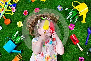 Little girl on a lawn with garden tools