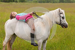 The little girl lay on her back white horse