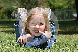 The little girl laying on a grass