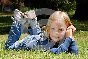 The little girl laying on a grass
