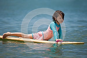 Little girl learn to surf at ocean