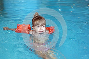 Little girl learn to swim in the pool