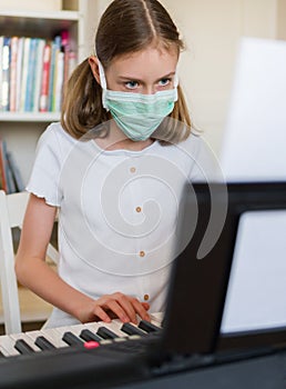 Little girl learning the piano during quarantine