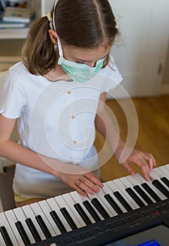 Little girl learning the piano during quarantine