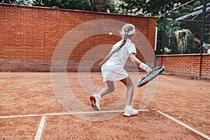 Little Girl learning to hit the tennis ball