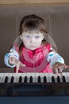Little girl learning to play piano. Concept of music study and creative hobby