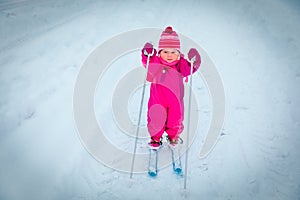 Little girl learning to ski in winter photo
