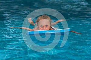Little girl learning to swim in big sport pool. Swimming school for small children. Healthy kid enjoying active lifestyle. Prescho