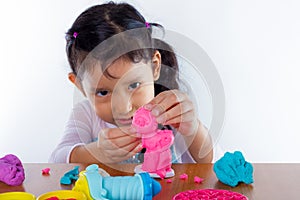 Little girl is learning to use colorful play dough