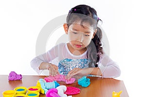Little girl is learning to use colorful play dough