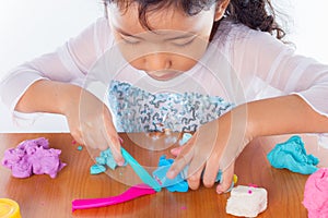 Little girl is learning to use colorful play dough