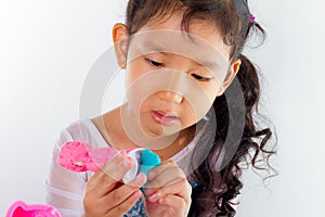 Little girl is learning to use colorful play dough