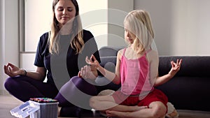 Little girl learning yoga with her teacher