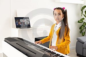 a little girl learns to play the synthesizer. learning to play musical instruments.