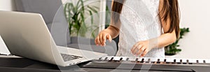 a little girl learns to play the synthesizer. learning to play musical instruments.