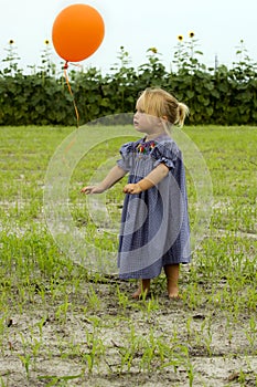 Little girl letting go of balloon