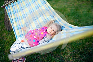 Little girl lies on a hammock