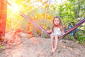 Little girl lies in a hammock