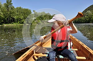 Little girl in a life jacket in a canoe