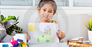 Little girl lift up colorful drawing family standing hold hands on planet earth on paper to camera