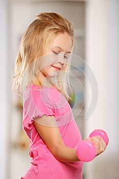 Little girl lifting a dumbbell