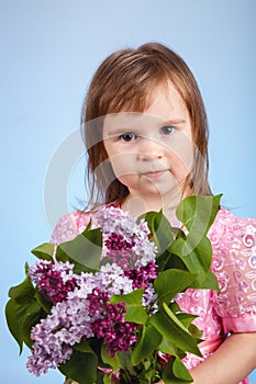 Little girl with lilac flower bouquet