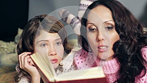 Little girl listening attentively to fairy tales, reading with mother, close up