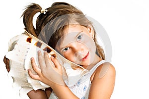 Little girl listening a huge seashell isolated