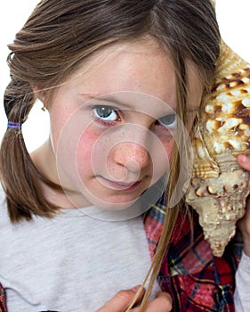 Little girl listening a shell