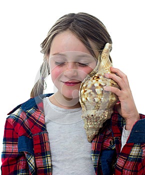 Little girl listening a shell