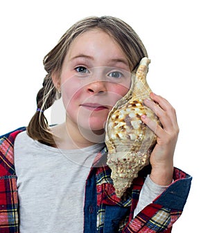 Little girl listening a shell