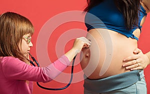 Little girl listening to mother's tummy