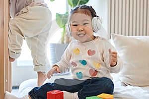 Little girl listening to music in headphones