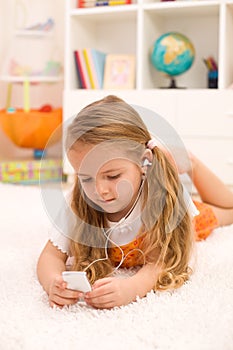 Little girl listening to music laying on the floor