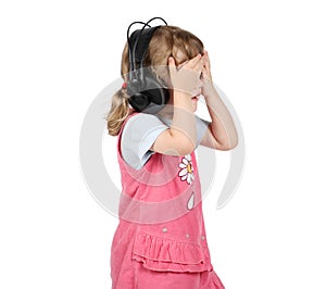 Little girl listens to music in big headphones and closed eyes