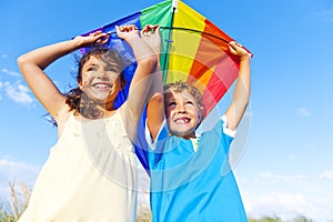 Little Girl And Little Boy Playing Kite Together photo